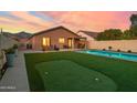 This backyard features a putting green, sparkling pool, and covered patio, perfect for outdoor relaxation and entertainment at 9013 E Shooting Star Dr, Gold Canyon, AZ 85118