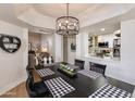 Modern dining room with black table and chairs, next to the white kitchen at 9121 W Topeka Dr, Peoria, AZ 85382