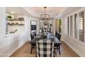 Stylish dining room with a long black table, checkered placemats, and decorative chandelier at 9121 W Topeka Dr, Peoria, AZ 85382