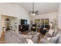 Open-concept living room with vaulted ceiling, wood floors, and a large window overlooking the backyard at 9121 W Topeka Dr, Peoria, AZ 85382