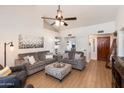 Bright living room featuring a high ceiling, wood-look floors, and cozy gray couches at 9121 W Topeka Dr, Peoria, AZ 85382