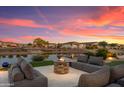 Comfortable outdoor living space with stylish seating around a stone fire pit near the water at 16683 S 180Th Dr, Goodyear, AZ 85338