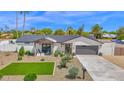 Beautiful front exterior shows white siding, a gray roof, manicured lawn, and a charming covered front porch with stylish seating at 11039 N 42Nd St, Phoenix, AZ 85028