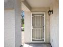 Covered entryway featuring a security screen door and exterior lighting at 1120 S Valley Dr, Apache Junction, AZ 85120