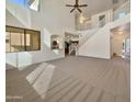 An empty living room with a staircase and lots of natural light at 1274 W Dexter Way, San Tan Valley, AZ 85143