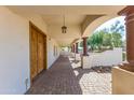 Inviting covered porch with brick pavers and decorative columns leading to the front door at 13051 N 70Th St, Scottsdale, AZ 85254