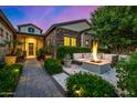 Cozy outdoor seating area featuring a modern fire pit, lush greenery, and ambient lighting at 17690 E Bronco Dr, Queen Creek, AZ 85142