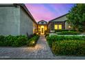 Inviting single-story home entrance with meticulously maintained landscaping and illuminated pathway at 17690 E Bronco Dr, Queen Creek, AZ 85142