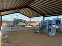 Community playground area with covered seating, play equipment, and an American flag at 18122 W Creedance Blvd, Surprise, AZ 85387