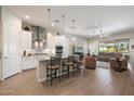 Bright kitchen with a tile backsplash, granite island with pendant lighting, and modern appliances at 18225 N 66Th Way, Phoenix, AZ 85054