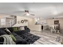 Open-concept living area features stylish plank floors, a ceiling fan, and seamless flow into the kitchen and dining area at 23119 W Papago St, Buckeye, AZ 85326