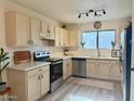 Modern kitchen with stainless steel appliances, white cabinets, and countertops, accented by neutral backsplash and flooring at 2358 E Peach Tree Dr, Chandler, AZ 85249