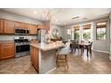 Open kitchen flows to the dining area with island, stainless steel appliances, and backyard views at 2418 W Jake Hvn, Phoenix, AZ 85085