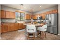 Bright kitchen with stainless appliances, barstool seating at island, and ample cabinet storage at 2418 W Jake Hvn, Phoenix, AZ 85085