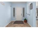 Inviting entryway with light blue walls, tile floors, and a white front door, creating a welcoming space at 26529 N 167Th Ave, Surprise, AZ 85387