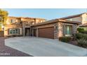 Beautiful two-story home with a stone facade, brown accents, three car garage, and a spacious driveway at 26529 N 167Th Ave, Surprise, AZ 85387