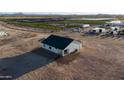 New construction home with dark roof, white exterior, large lot and nearby trees and shrubs at 3880 S 331St Ave, Tonopah, AZ 85354