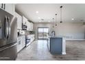 Kitchen boasts stainless steel appliances, granite counters, and gray island at 3887 S 331St Ave, Tonopah, AZ 85354