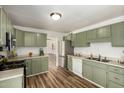 Bright kitchen featuring stylish green cabinetry, stainless steel appliances, and wood-look floors at 3913 W Krall St, Phoenix, AZ 85019