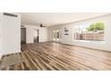 Airy living room with expansive window and french doors highlighting the natural light and wood-look flooring at 3913 W Krall St, Phoenix, AZ 85019