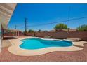 Inviting backyard showcasing a kidney-shaped pool with a sunbathing deck and lounge chair at 3913 W Krall St, Phoenix, AZ 85019