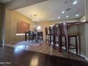Cozy dining area featuring a wooden table, chairs, and a stylish chandelier at 44328 W Knauss Dr, Maricopa, AZ 85138