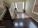 Inviting foyer showcasing tile flooring, staircase, and natural light filtering through windows at 44328 W Knauss Dr, Maricopa, AZ 85138