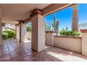 Covered patio with tile flooring and brick accents, showcasing desert landscaping and natural light at 4442 E Redfield Rd, Phoenix, AZ 85032