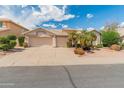 Charming single-story home featuring well-manicured landscaping, a three-car garage, and a neutral color palette at 5936 W Via Montoya Dr, Glendale, AZ 85310