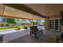 Spacious covered back patio with chairs, outdoor seating, and sliding doors to the home at 6401 N 82Nd Way, Scottsdale, AZ 85250