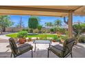 Inviting covered back patio with comfortable seating and a view of the lush green backyard at 6401 N 82Nd Way, Scottsdale, AZ 85250