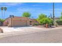 Charming single-story home features a two-car garage, desert landscaping, and a basketball hoop at 6401 N 82Nd Way, Scottsdale, AZ 85250