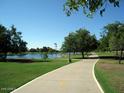Picturesque walking path winding through a park with a lake and lush green trees at 6401 N 82Nd Way, Scottsdale, AZ 85250