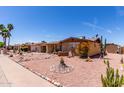 Exterior view of a charming brick home featuring desert landscaping, mature plants and rock features at 962 S Main Dr, Apache Junction, AZ 85120