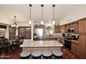 Spacious kitchen features a large island, stainless steel appliances, and custom wood cabinetry at 10974 S Dreamy Dr, Goodyear, AZ 85338