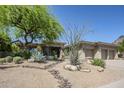Charming desert landscaping and mature trees enhance this property's curb appeal at 11088 E Acacia Dr, Scottsdale, AZ 85255