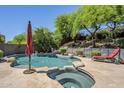 Serene pool and spa with stone accents, mature trees and a lounge chair at 11088 E Acacia Dr, Scottsdale, AZ 85255