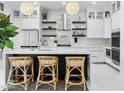 Stylish kitchen with white cabinets, an island with seating, and modern lighting fixtures at 11116 N 78Th St, Scottsdale, AZ 85260
