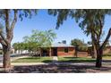 Quaint brick home surrounded by mature trees and a well-maintained lawn at 1546 W Culver St, Phoenix, AZ 85007