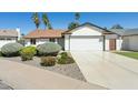 Charming single-story home with a manicured front yard, a two-car garage, and a well-maintained lawn at 15629 N 63Rd Pl, Scottsdale, AZ 85254