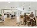 Open-concept living room featuring light wood floors, a kitchen island, and comfortable seating at 15629 N 63Rd Pl, Scottsdale, AZ 85254