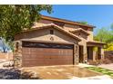 Attractive two-story home boasting stone accents, a two-car garage, and a well-maintained front yard at 16102 W Redfield Rd, Surprise, AZ 85379