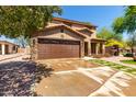Beautiful two-story home with stone accents, a well-kept lawn, and a practical two-car garage at 16102 W Redfield Rd, Surprise, AZ 85379