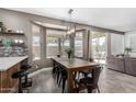 Bright dining room with large windows, modern light fixture, and backyard access at 1721 W South Fork Dr, Phoenix, AZ 85045