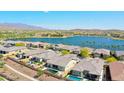 An aerial view of the community, showing the lake, homes, desert landscaping, and nearby mountains at 18166 W Hope Dr, Goodyear, AZ 85338
