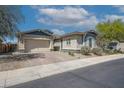 Charming home with a three-car garage, stone accents, and well-maintained landscaping, creating curb appeal at 18166 W Hope Dr, Goodyear, AZ 85338