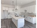 New kitchen features white cabinets, an island, modern light fixtures and stainless steel appliances at 1819 S Coconino S Dr, Apache Junction, AZ 85120