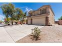 Corner angle of this two-story home with a spacious driveway, a two-car garage, and desert landscaping at 2174 N Wildflower Ln, Casa Grande, AZ 85122