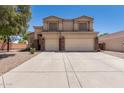 Two-story home featuring a spacious driveway, a two-car garage, and desert landscaping at 2174 N Wildflower Ln, Casa Grande, AZ 85122