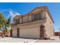 Side angle shows this two-story home with a large driveway, a two-car garage, and desert landscaping at 2174 N Wildflower Ln, Casa Grande, AZ 85122